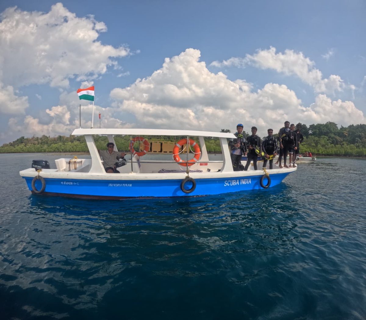 The Scuba India dive boat with the Indian flag on calm blue water off Havelock